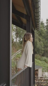 Video de una chica rubia, vestida con estilo, contemplando desde el balc&oacute;n del ventanal las impresionantes laderas de una monta&ntilde;a. Una fusi&oacute;n de moda y naturaleza en un solo cuadro.