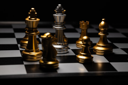 Chess king, surrounded by opponents in a dark room. For creating business-related content
