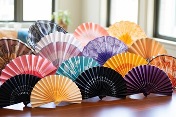a variety of colorful hand fans spread out on a white table