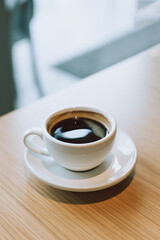 Cup of black coffee on a table in a cafe.