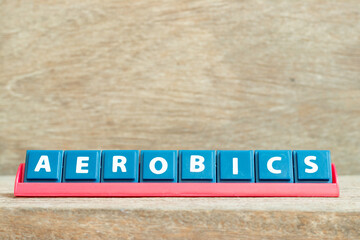 Tile alphabet letter with word aerobics in red color rack on wood background