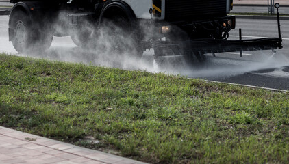  car for watering the road waters the sidewalk