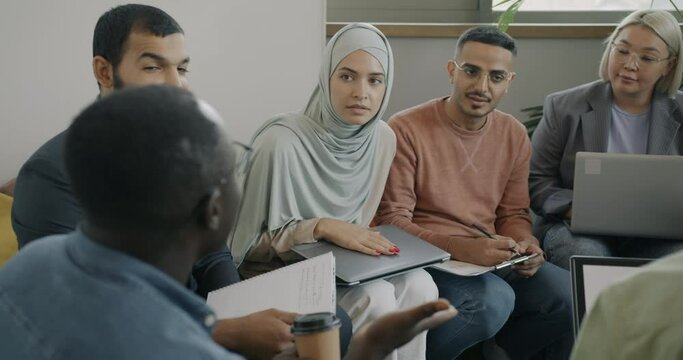 Ambitious men and women diverse team talking sharing business ideas in coworking office. Businesspeople and communication concept.