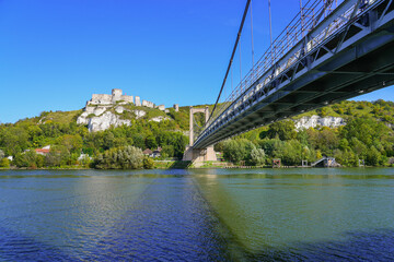 Suspension bridge of Les Andelys spanning the River Seine under the ruins of Château Gaillard, a medieval castle sitting on top of limestone cliffs built by Richard the Lionheart in Normandy, France