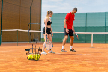 a young coach teaches a beginner girl to play tennis, practice movements with a racket practice...