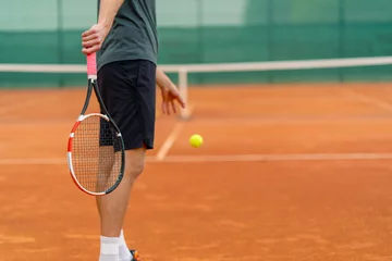Fotobehang young professional player coach on outdoor tennis court practices strokes with racket and tennis ball © Guys Who Shoot