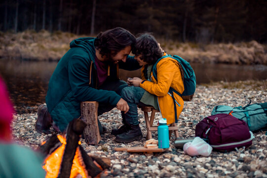 Young Caucasian father bonding with his son while camping and hiking in the forest