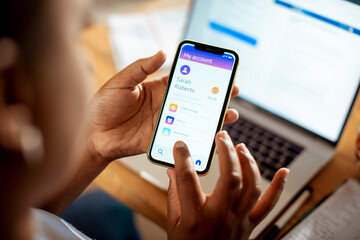 Young African American woman using her bank app on the smartphone at home