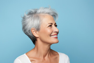 Radiant Senior Beauty: Portrait of a Beautiful Senior Woman with a Bright Smile, Clean Teeth, and Flawless Skin, Isolated on a Serene Light Blue Background..