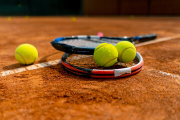 close-up of sports equipment, tennis rackets and balls lie on an outdoor ground court hobby competition sport