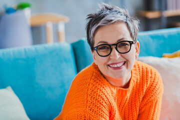 Photo of positive lovely aged person toothy smile good mood sit cozy couch spend free time...