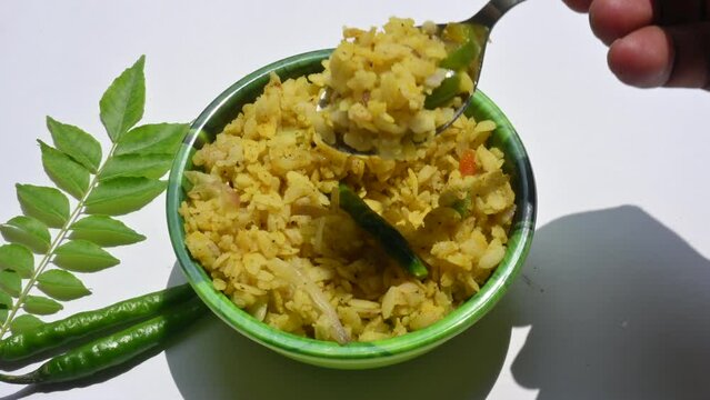 Vegetable Poha in India. It is made by mixing vegetables, poha and spices. Rice is parboiled before flattening so that it can be consumed with very little to no cooking. Indian breakfast.