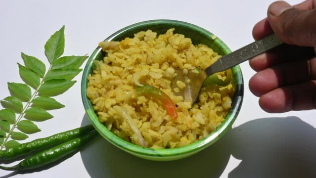 Vegetable Poha in India. It is made by mixing vegetables, poha and spices. Rice is parboiled before flattening so that it can be consumed with very little to no cooking. Indian breakfast.