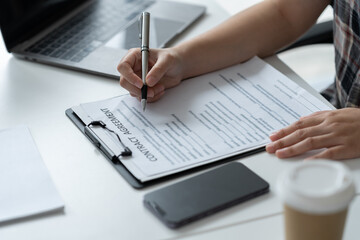 Businesswoman, office worker working using laptop and mobile phone in real estate accounting analysis reporting, discussing agreement contract documents financial and tax system concepts.