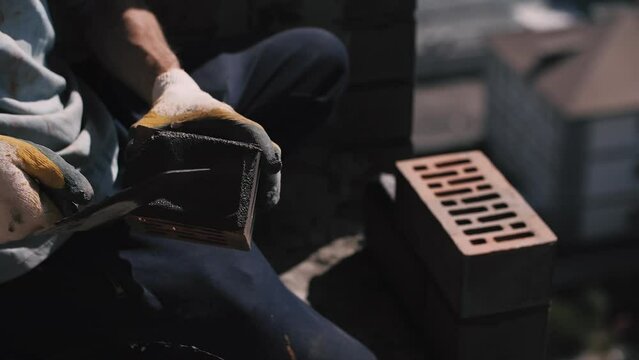 Builder lays a wall of red bricks. Building materials.