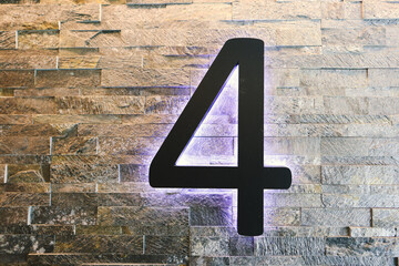Dark  Neon Font with fluorescent purple tubes  Number 4 on the dark brown brick wall.  Night Show Alphabet.