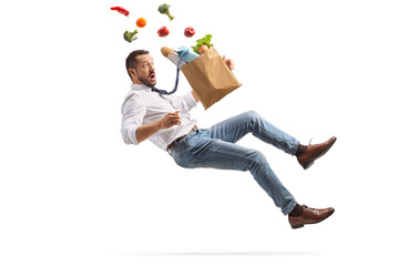 Full length shot of a young man with a grocery bag falling - obrazy, fototapety, plakaty