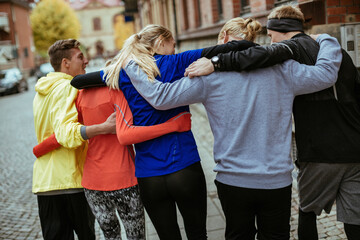 Young and diverse group of city Runners Embracing After a Successful Workout
