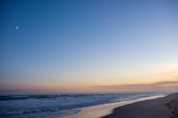 The moon and the fading day over the ocean in the hamptons, ny