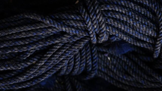 rolls of natural hemp wire for parcel twine, string, packing or diy.fencing strand,polypropylene orange, blue twine.spools in plastic bag,woman hand,market store sale concept.thick rope texture