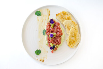 Tuna tartare with mint kiwi avocado cream and ciabatta croutons isolated