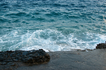 Sea waves break on a rocky beach, a coastline nature concept.