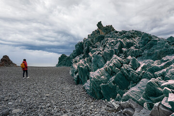 Poised between earth and tide: A muse emerges amid Djúpalónssandur's ancient stones, echoing...