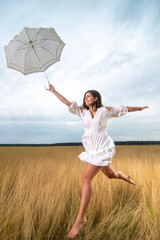 Young girl jumping with happiness exuberantly with umbrella