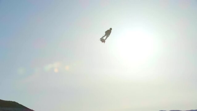 Sunrise with man in jetpack flying high above