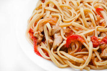 Korean Udon noodles with meat on a white plate. Delicious spicy meat breakfast.