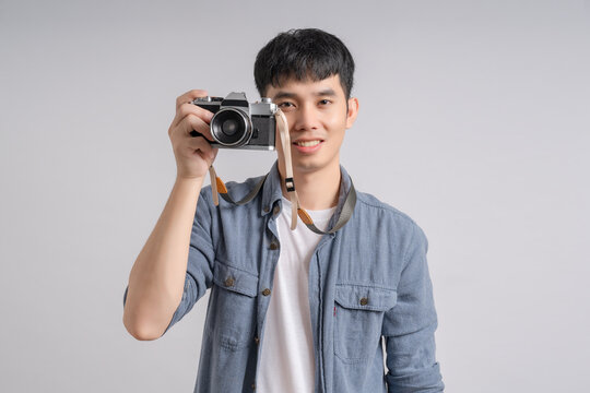 Person man holding camera and smiling happily.