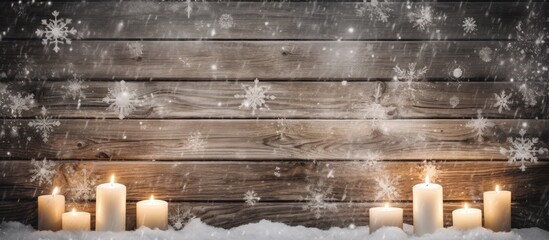 Glowing white holiday candles on wooden cross in snow religious Christmas and Easter background
