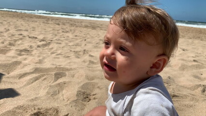 Baby infant at the beach feeling the sand with toes and feet barefeet