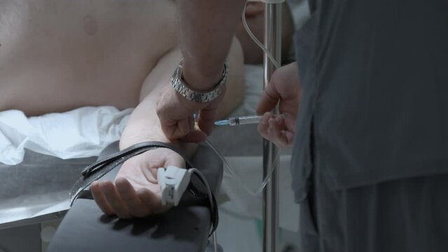 Doctor hands in gloves with syringe. Stock footage. Medical specialist in blue uniform making an injection to a patient.