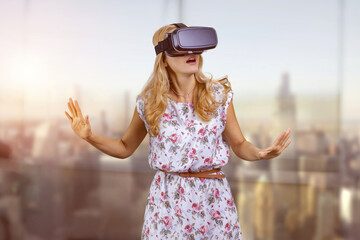 Portrait of blonde woman in VR headset. Abstract blurred background.