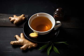 Ginger tea with mint and lemon on a dark wooden background
