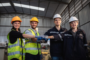 Team engineers and foreman stack hand and shake hands to show success at factory machines. Workers...