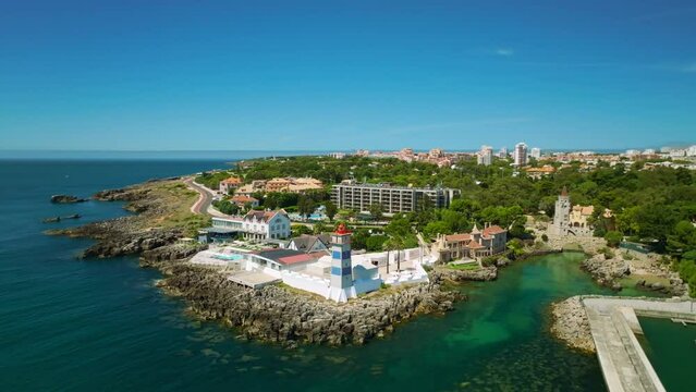 Aerial drone view of Santa Marta lighthouse with Cascais cityscape, Portugal. Orbit parallax shot