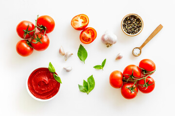 Tomato sauce passata in bowl with fresh tomatoes and basil