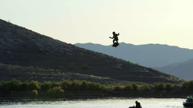 Man flying in sky with jet pack and slowing down