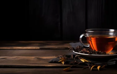 Poster Fresh hot black tea in a cup on a dark rustic background © pilipphoto
