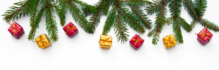 Branches of a Christmas tree and red and yellow gift boxes on a white background. Christmas background with copyspace.
