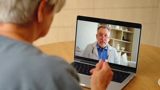 Senior Man Doctor Expert Examining Older Senior Woman Online. Old Woman Lady Patient And Doctor Talk On Video Call Have Consultation With Laptop. Medicine Healthcare Medical Checkup. Online Doctor