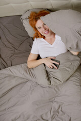 top view of happy caucasian woman awake smiling in bed with copy space