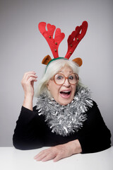 older woman with christmas items looking at the camera