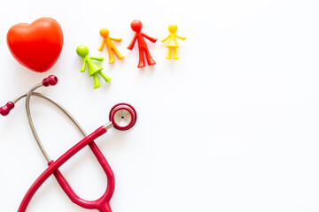 Family medicine concept. Stethoscope and family rubber figurines, top view