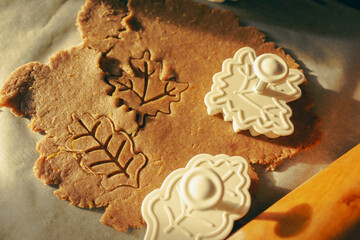 Autumn leaf cookie cutter and gingerbread dough. Rolling pin and spicy pastry. Autumn festive...