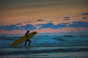 Surfer in the North Sea in the Netherlands at night