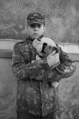 A child in a military uniform with a dog. Black and white photo