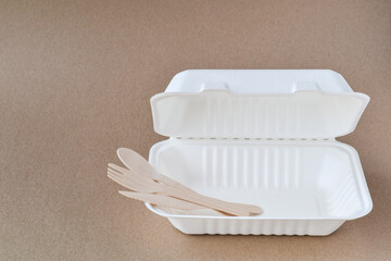Single use biodegradable wooden bamboo utensils inside a take out container